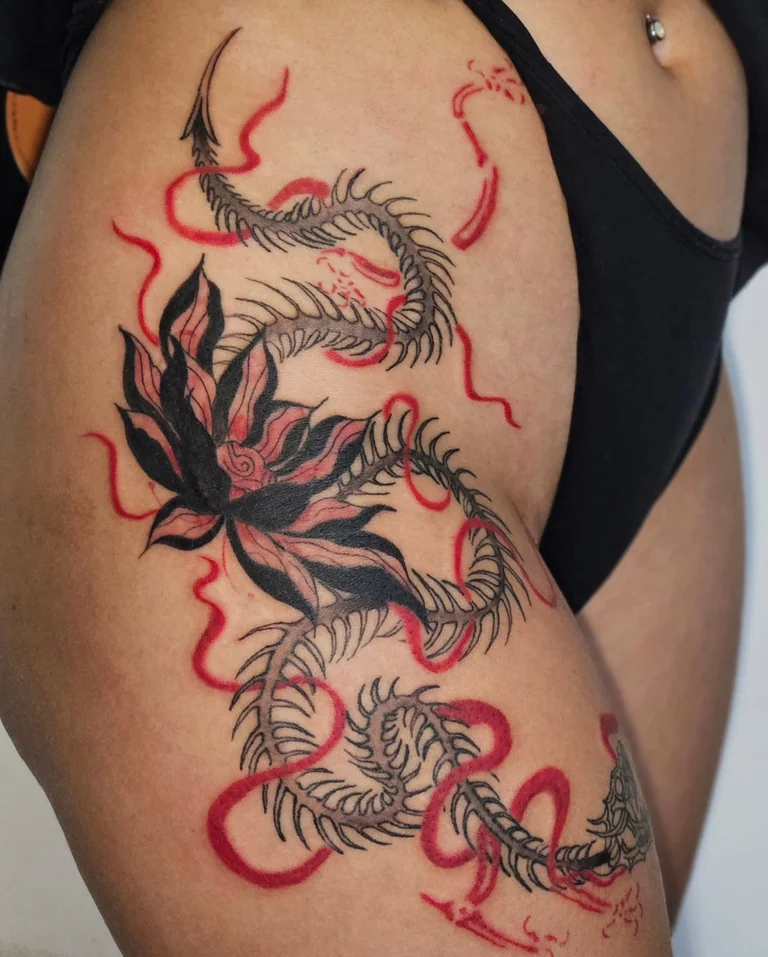 Composição autoral em blackwork com detalhes em vermelho na coxa
